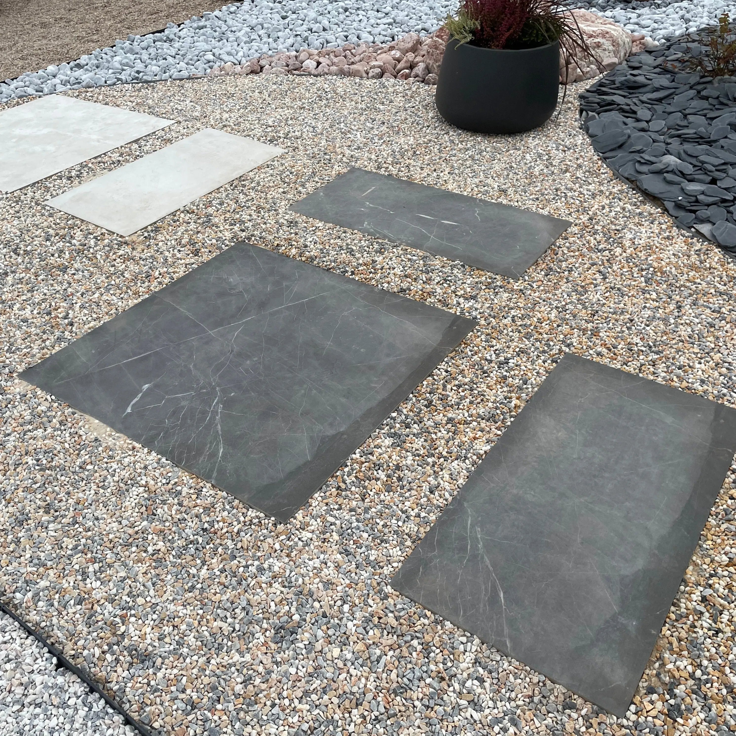 Losa porcelánica efecto mármol negro, perfecta para decorar jardines y exteriores con elegancia.